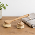 Bamboo dish brush with replaceable head on a wooden kitchen counter